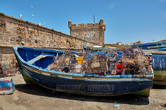 fishing boat with weirs in front of citadel of  Essaouira