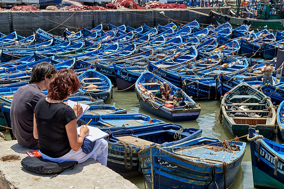 painters and fishing boats in harbor of Essaouira