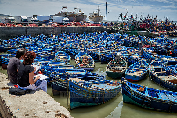 painters and fishing boats in harbor of Essaouira