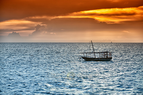 dhow swings in sea at sunset