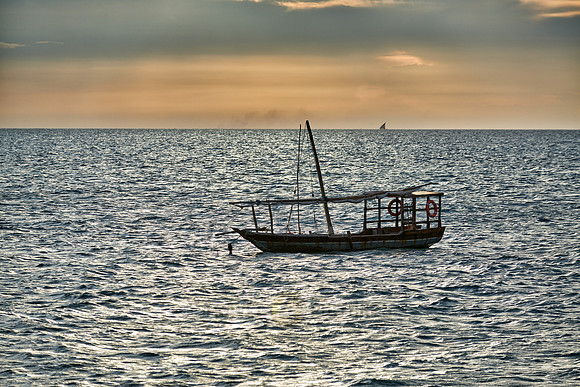 dhow swings in sea at sunset