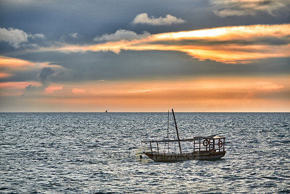 dhow swings in sea at sunset