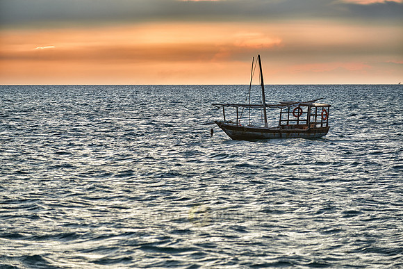 dhow swings in sea at sunset