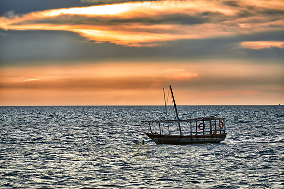 dhow swings in sea at sunset