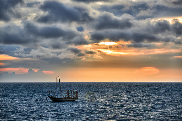 dhow swings in sea at sunset