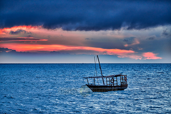 dhow swings in sea at sunset
