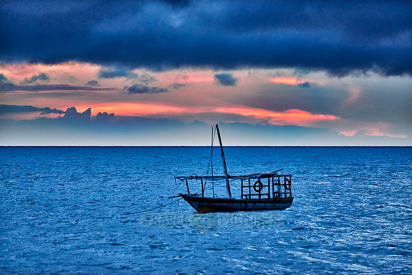 dhow swings in sea at sunset