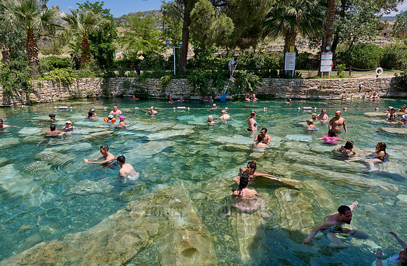 people swimming in natural swimming pool with columns in Greek Hierapolis