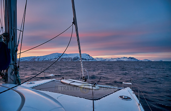 sunrise over fjord with winter landscape seen from sail ship