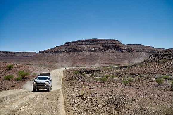 4x4 cars on deserted gravel road in desert landscape