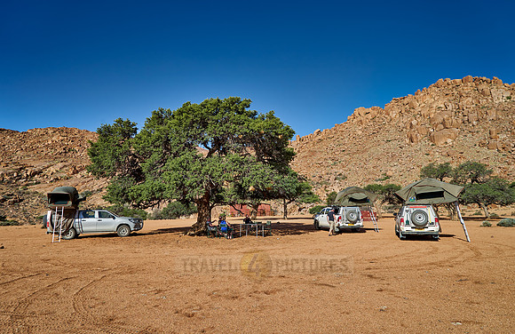 tourists in self-drive 4x4 car camping in desert landscape