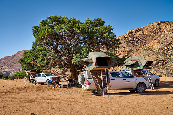 tourists in self-drive 4x4 car camping in desert landscape