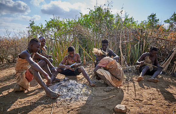 bushmen of Hasabe tribe sitting around a fireplace