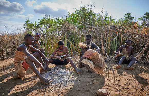bushmen of Hasabe tribe sitting around a fireplace
