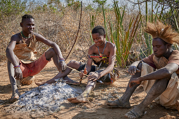 bushmen of Hadzabe tribe sitting around a fireplace
