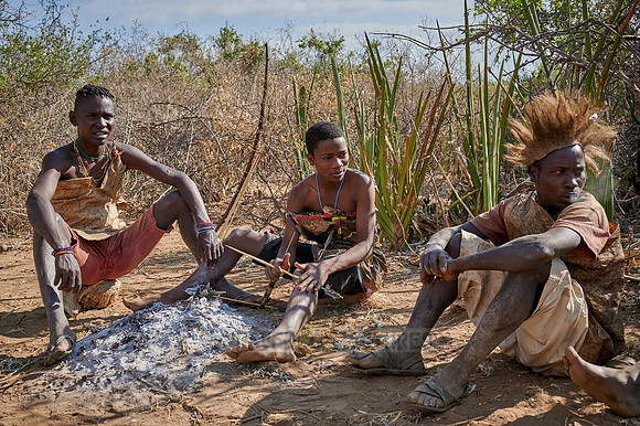 bushmen of Hasabe tribe sitting around a fireplace