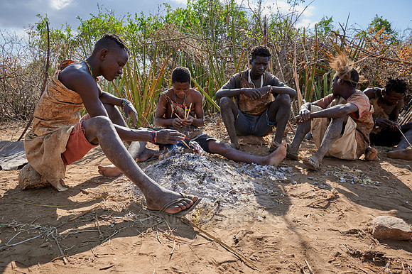 bushmen of Hasabe tribe sitting around a fireplace