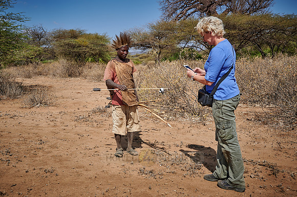 tourist with hunting bushmen of Hadza tribe