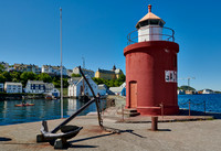 lighthouse and anchor  at entrance of old harbor