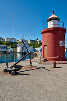 lighthouse and anchor  at entrance of old harbor