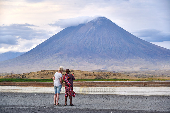 tourist and guide in front of Ol Doinyo Lengai vulcano