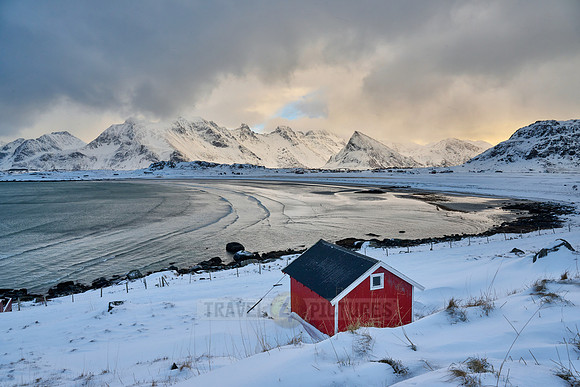 red hut in winter landscape with sea and mountains at Sandbotnen, Lofoten,