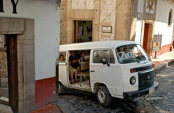 VW bus as a shared taxi turns on the Plaza Borda