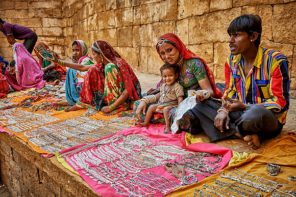 colorful and traditionally dressed people selling souvenirs