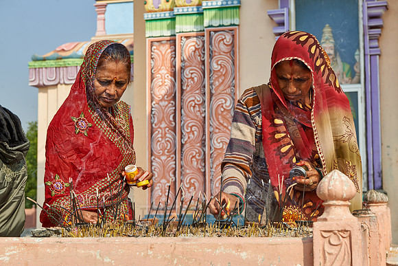 Women in colorful saris in front typical colorful temple