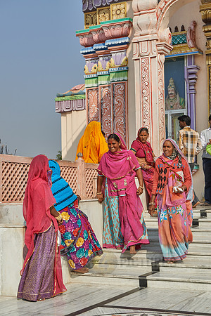Women in colorful saris in front typical colorful temple