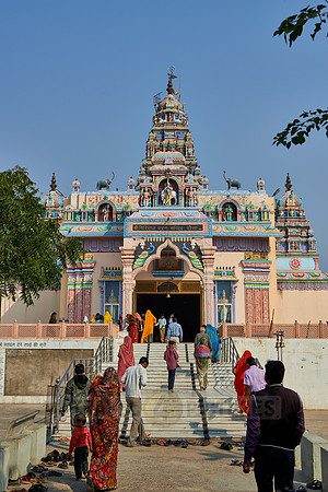 Women in colorful saris in front typical colorful temple