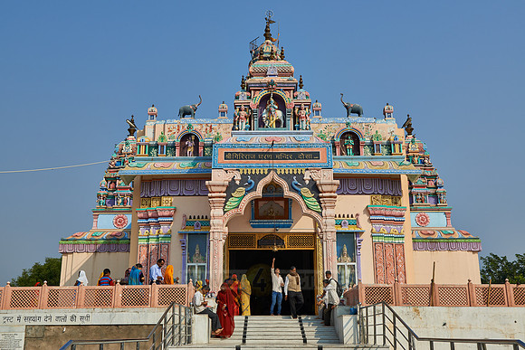 Women in colorful saris in front typical colorful temple