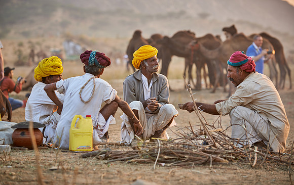 nomadic tribe men with traditional turbans haggle for prices