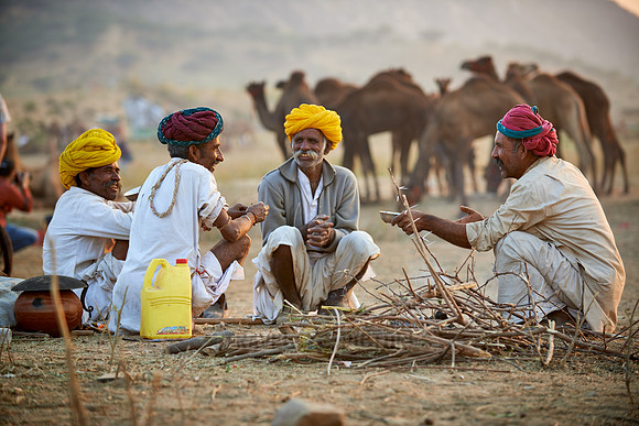 nomadic tribe men with traditional turbans haggle for prices