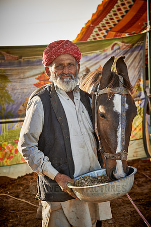 man feeding horse on Puskar Mela
