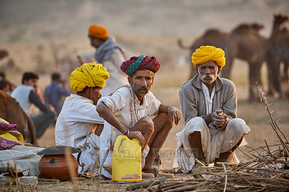 nomadic tribe men with traditional turbans haggle for prices