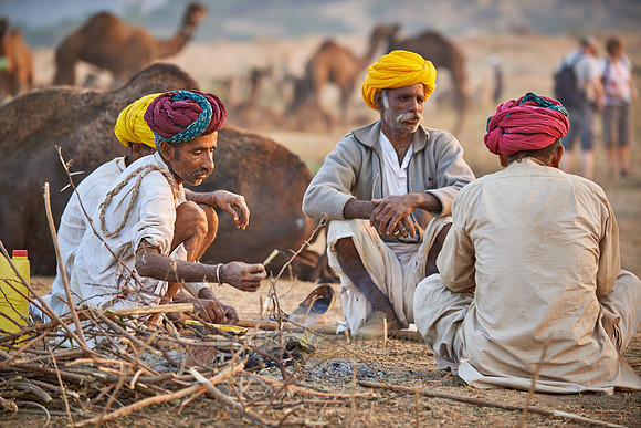 nomadic tribe men with traditional turbans haggle for prices