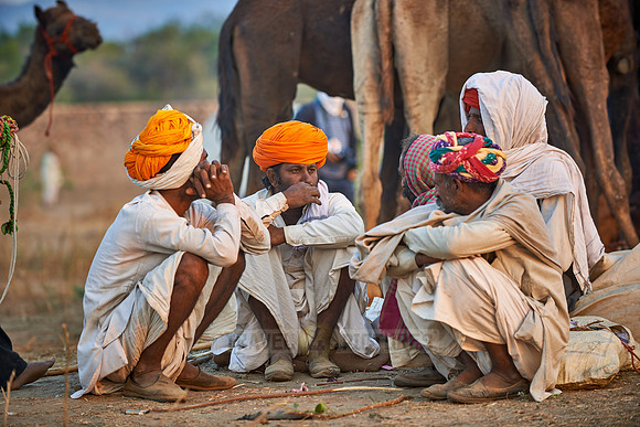 nomadic tribe men with traditional turbans haggle for prices