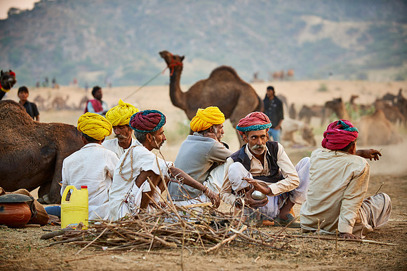 nomadic tribe men with traditional turbans haggle for prices
