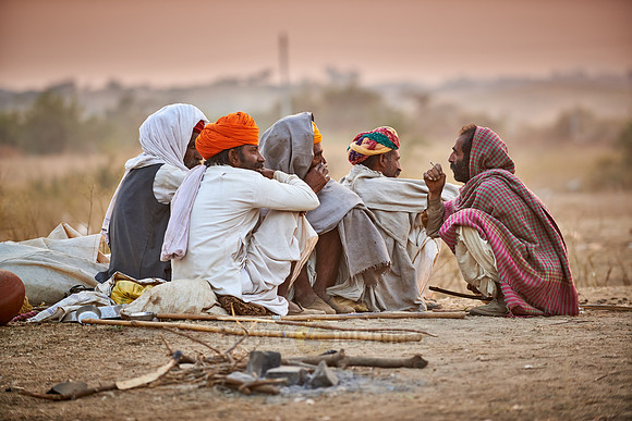 nomadic tribe men with traditional turbans haggle for prices