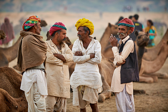 nomadic tribe men with traditional turbans haggle for prices