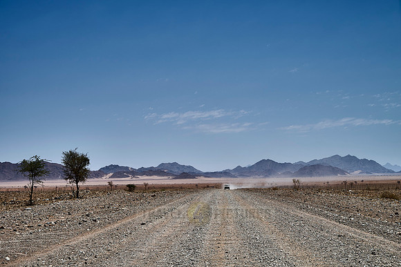 straight deserted gravel road in desert landscape