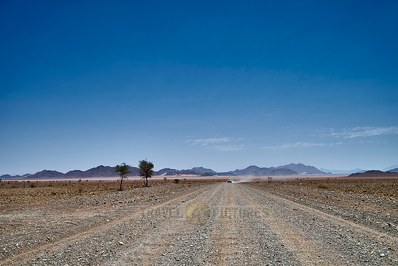 straight deserted gravel road in desert landscape