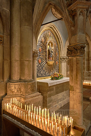 Candles beneath small altar with Mary & the baby Jesus figures inside theDom St. Peter cathedral
