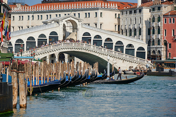 Rialto Bridge seen from boat with gondulas in front
