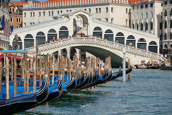 Rialto Bridge seen from boat with gondulas in front