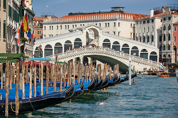 Rialto Bridge seen from boat with gondulas in front