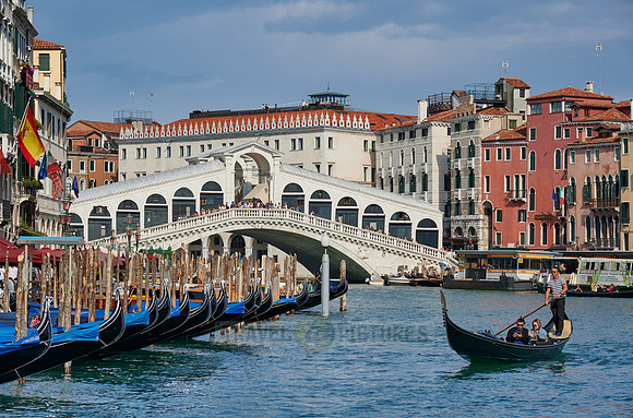 Rialto Bridge seen from boat with gondulas in front