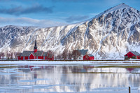 Red church of Flakstad with reflection in the water