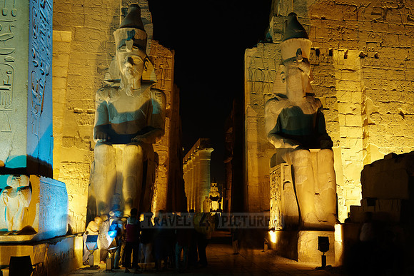 night shot of illuminated statues of Ramesses II. in front of first Pylon